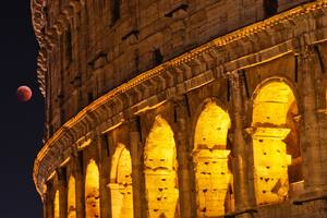 El eclipse lunar completo a un lado del Coliseo Romano