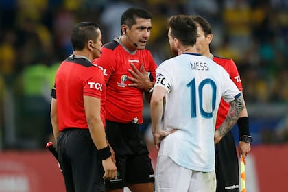 El ecuatoriano Roddy Zambrano, árbitro del partido, le da explicaciones a Lionel Messi