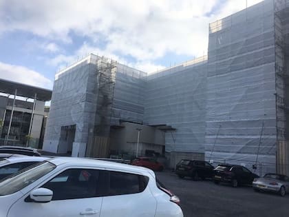 El edificio cubierto de andamios y de una red de seguridad