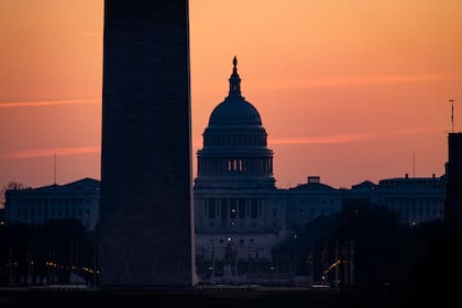 El edificio del Capitolio de Estados Unidos se ve más allá del Monumento a Washington cuando sale el sol el 27 de diciembre de 2020 en Washington, DC