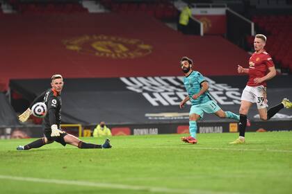 El egipcio Mohamed Salah anota el cuarto gol de Liverpool ante Manchester United en el encuentro de la Liga Premier disputado el jueves 13 de mayo de 2021 (Peter Powell/Pool via AP)
