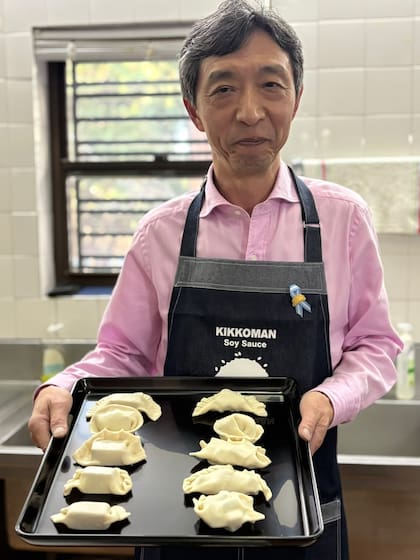 El embajador con su delantal de cocina y su bandeja de empanadas