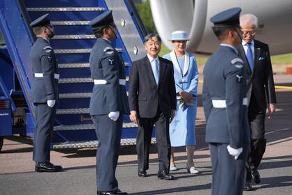 El emperador Naruhito y la emperatriz Masako de Japón pasan junto a una guardia de honor tras llegar al aeropuerto de Stansted, Inglaterra, el sábado 22 de junio de 2024, antes de una visita de Estado. (AP Foto/Kin Cheung)
