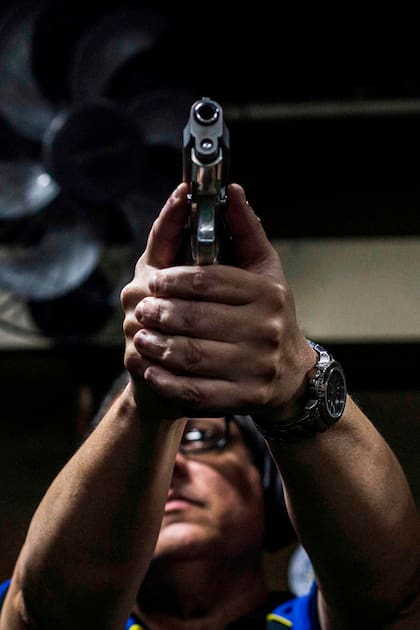 Un hombre sostiene un arma en el club de tiro Calibre 12 en Sao Goncalo, Río de Janeiro