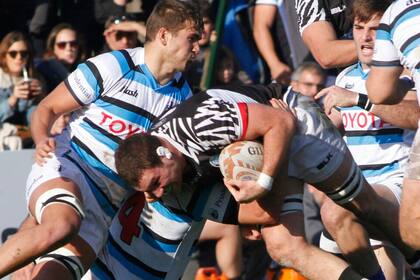 El empuje del tercera línea del CASI Juan Ymaz, entre varios rivales.