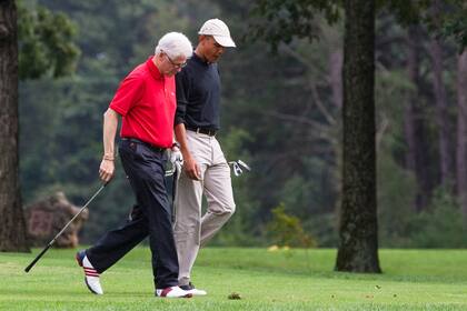 El entonces Barack Obama, derecha, conversa con el expresidente Bill Clinton durante una ronda de golf en la Base Aérea Andrews