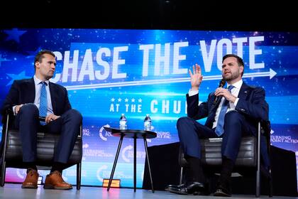 El entonces candidato republicano a la vicepresidencia de EEUU, el senador JD Vance, a la derecha, habla en un mitin de campaña mientras el fundador de Turning Point USA, Charlie Kirk, a la izquierda, escucha, el 4 de septiembre de 2024, en Mesa, Arizona