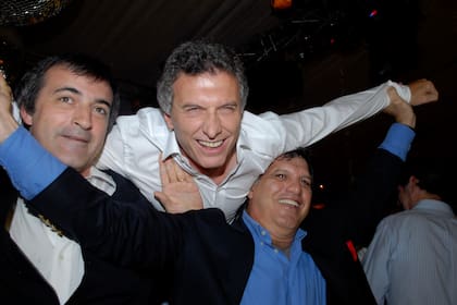 El entonces ministro de Educación porteño, Esteban Bullrich, y Gianfranco Macri levantaron a Mauricio por el aire.