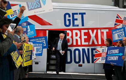 El entonces primer ministro británico, Boris Johnson, se dirige a sus seguidores antes de subir a un autobús de campaña electoral en Manchester