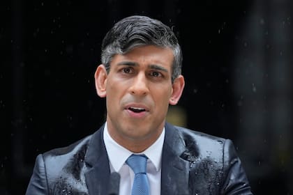 El entonces primer ministro británico, Rishi Sunak, habla mientras cae una intensa lluvia, ante el 10 de Downing Street en Londres
