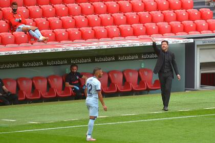 El entrenador argentino del Atlético de Madrid, Diego Simeone (der), da instrucciones a sus jugadores durante el partido de fútbol de la Liga española entre el Athletic Club de Bilbao y el Club Atlético de Madrid en el estadio de San Mamés en Bilbao el 14 de junio de 2020.