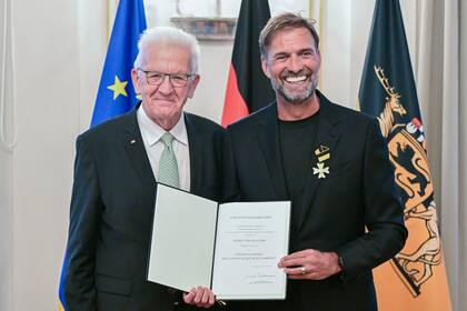 El entrenador de fútbol Juergen Klopp, a la derecha, recibe la Orden del Mérito del Estado alemán de Baden-Württemberg en Stuttgart, Alemania, el martes 8 de octubre de 2024, de manos del gobernador Winfried Kretschmann, a la izquierda, por su amplio compromiso social fuera del deporte. (Bernd Weissbrod/dpa vía AP)