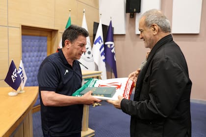 El entrenador de la selección de Irán, Amir Ghalenoei, junto al presidente del país, Masoud Pezeshkian, en Teherán, el 13 de mayo de 2026.