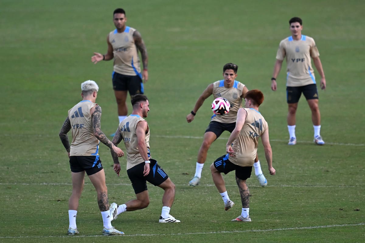 El entrenamiento argentino en Barranquilla; Lisandro Martínez, Alexis Mac Allister, Valentín Barco y Giuliano Simeone, y la pelota en el centro; detrás observan Lautaro Martínez y Julián Álvarez. (Photo by Raul ARBOLEDA / AFP)