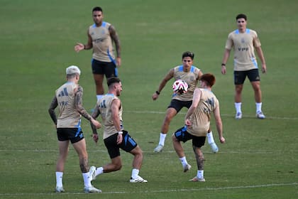 El entrenamiento argentino en Barranquilla; Lisandro Martínez, Alexis Mac Allister, Valentín Barco y Giuliano Simeone, y la pelota en el centro; detrás observan Lautaro Martínez y Julián Álvarez. (Photo by Raul ARBOLEDA / AFP)