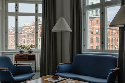 El equipamiento: sillón ‘FJ 01’, sofá ‘FJ 02’, la mesa con sus característicos cajones sin tirantes, enmarcadas por elegantes cortinados y moquette grises.