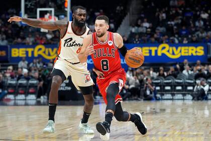 El escolta de los Bulls de Chicago, Zach LaVine (8), conduce mientras el alero de los Pistons de Detroit, Tim Hardaway Jr. (8), defiende durante la primera mitad, el lunes 18 de noviembre de 2024, en Detroit. (AP Foto/Carlos Osorio)