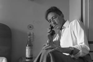 El escritor francés Jean Cocteau, sentado en su cama, hablando por teléfono, París, 1947