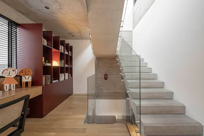 El escritorio de enchapado de roble americano y la biblioteca laqueada con el tono ‘Chocolate con Chili’ (Alba) son diseños de Griot Concept ejecutados por Ral Design