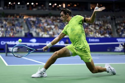 El esfuerzo de Mariano Navone para pegar de revés desde el fondo de la cancha (Photo by JULIAN FINNEY / GETTY IMAGES NORTH AMERICA / Getty Images via AFP)