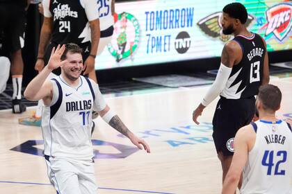 El esloveno Luka Doncic (izquierda), de los Mavericks de Dallas, festeja con Maxi Kleber, en el segundo partido de la serie de playoffs ante los Clippers de Los Ángeles, el martes 23 de abril de 2024 (AP Foto/Mark J. Terrill)