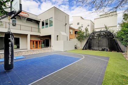 El espacio exterior incluye pileta, jacuzzi, galería techada con chimenea y una cancha de básquet privada dentro de un entorno cerrado