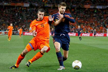 El español Gerard Piqué (der) lucha por el balón con el holandés Robin van Persie durante su último partido de fútbol de la Copa Mundial de 2010 en el estadio Soccer City en Johannesburgo el 11 de julio de 2010.