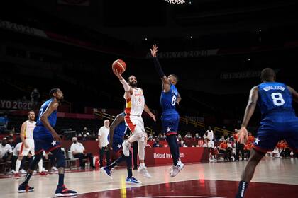 El español Ricky Rubio va a la canasta ante el estadounidense Damian Lillard en el partido de cuartos de final de baloncesto masculino entre España y Estados Unidos.