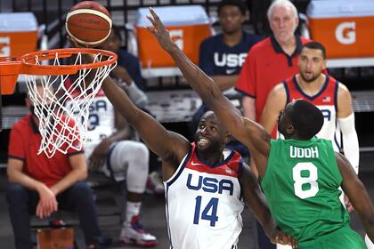 El estadounidense Draymond Green (14) dispara contra el nigeriano Ekpe Udoh (8) durante un juego de exhibición de baloncesto el sábado 10 de julio de 2021 en Las Vegas.