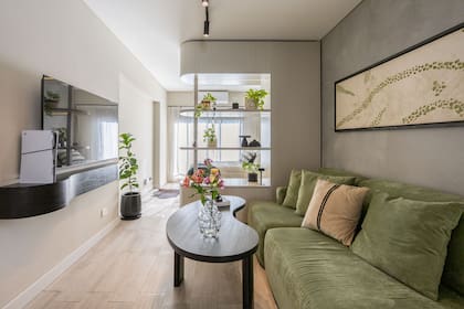 El estante del sector de TV y la mesa ratona se hicieron en madera de paraíso laqueada en negro con poro abierto, para sumar calidez y contraste.