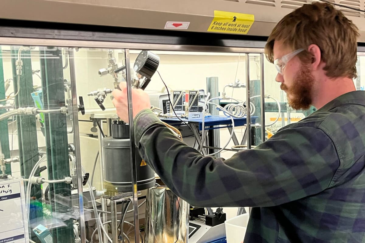 El estudiante de posgrado RJ Conk ajusta una cámara de reacción en la que los plásticos mezclados se degradan en los bloques de construcción reutilizables (Crédito: Robert Sanders, Universidad de California en Berkeley)