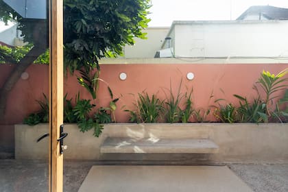 El Estudio diseñó un banco-cantero que funciona como una extensión del interior. Apliques de pared 'Skote' (Luminocity). Alfombra lavable (Tramma Rugs), la misma del living.