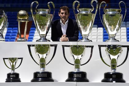 El ex arquero del Real Madrid, Iker Casillas, posa con los trofeos que ganó con el Real Madrid después de una conferencia de prensa en el estadio Santiago Bernabeu de Madrid. - El arquero español ganador de la Copa del Mundo, Iker Casillas, anunció su retiro el 4 de agosto de 2020.