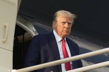 El ex presidente Donald Trump desciende de su avión al llegar al Aeropuerto Internacional Hartsfield-Jackson de Atlanta, el jueves 24 de agosto de 2023, en Atlanta.