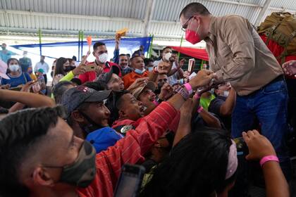 El excanciller Jorge Arreaza, a la derecha, saluda a simpatizantes durante un evento el domingo 5 de diciembre de 2021, en Barinas, Venezuela. (AP Foto/Ariana Cubillos)