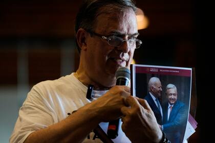 El excanciller mexicano Marcelo Ebrard muestra un reporte de su gestión como ministro de Relaciones Exteriores, presentado con una foto del presidente de México, Andrés Manuel López Obrador y del presidente de Estados Unidos, Joe Biden, en una conferencia de prensa en una librería en Ciudad de México, el lunes 12 de junio de 2023. Ebrard anunció el lunes 19 de junio de 2023 que, de ganar la candidatura de Morena y ser electo presidente, colocaría al hijo del mandatario, Andrés Manuel López Beltrán, a cargo de una nueva secretaría dedicada a la "cuarta transformación". (AP Foto/Fernando Llano)