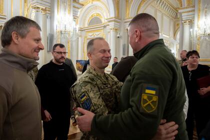 El excomandante en jefe de las Fuerzas Armadas de Ucrania, Valery Zaluzhny, a la derecha, y su sucesor,Oleksander Sirski, se abrazan durante una ceremonia de premiación en Kiev, el 9 de febrero de 2024. (Oficina de Prensa Presidencial de Ucrania vía AP)