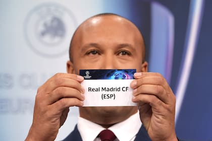 El exdefensor francés Mikael Silvestre muestra la bolilla de Real Madrid, que quedó emparejado con Chelsea en los cuartos de final de la Champions League