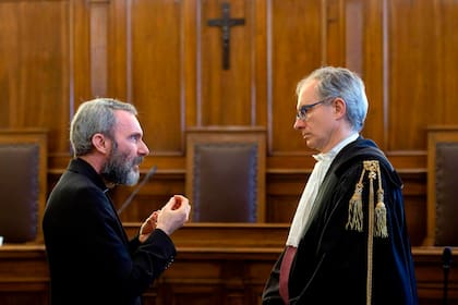El exdiplomático de la Santa Sede monseñor Carlo Alberto Capella (izq.) habla con su abogado, Roberto Borgogno, dentro de un tribunal del Vaticano