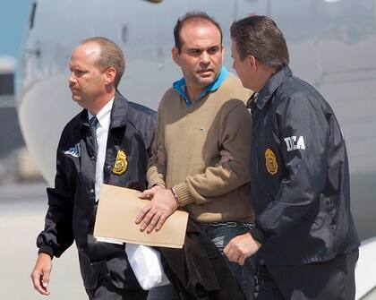 El exjefe paramilitar colombiano Salvatore Mancuso es escoltado por agentes de la DEA de Estados Unidos a su llegada a Opa-locka, Florida, el 13 de mayo de 2008. (Archivo)