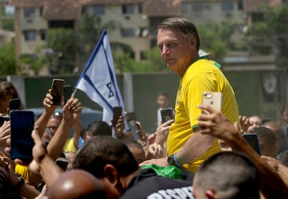El expresidente brasileño Jair Bolsonaro es rodeado por sus simpatizantes en un evento de campaña el 16 de marzo de 2024, en Río de Janeiro.