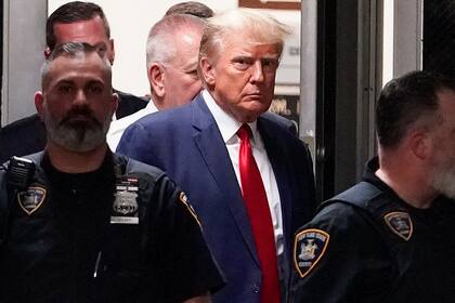 El expresidente Donald Trump es acompañado hacia la sala de un tribunal, el 4 de abril de 2023, en Nueva York. (AP Foto/Mary Altaffer, Archivo)