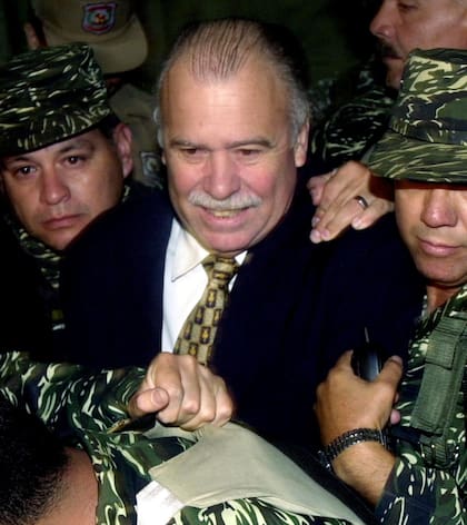El expresidente paraguayo Raúl Cubas Grau es llevado a una corte en Asunción, en 2002