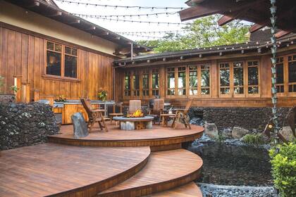 El exterior de la casa tiene una fuerte presencia de madera que convive con la frondosa vegetación local
