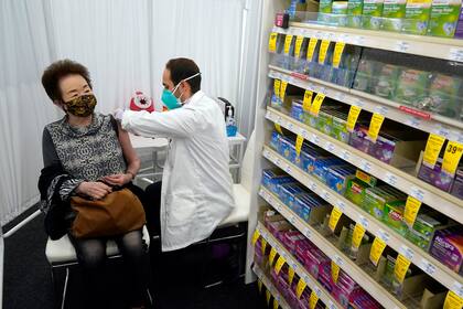 El farmacéutico Todd Gharibian administra una dosis de la vacuna contra el COVID-19 de Moderna a Toshiko Sugiyama, en una farmacia CVS en 1 de marzo de 2021 en Los Ángeles. (AP Foto/Marcio Jose Sanchez, Archivo)