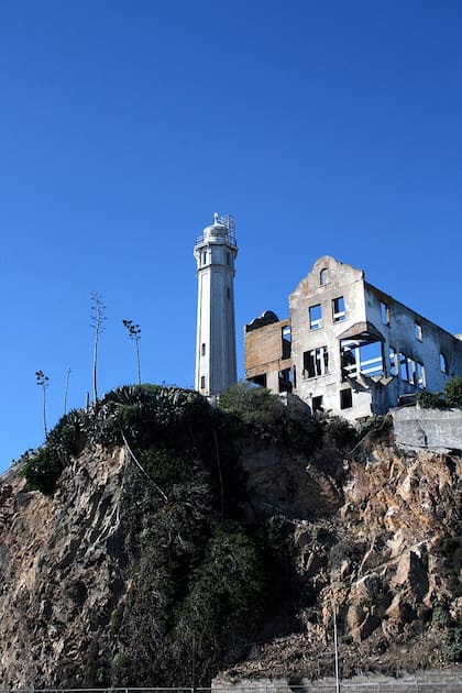 El faro y las ruinas de lo que era la casa del director de la prisión, arriba de los acantilados