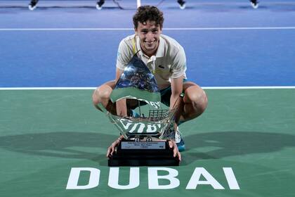 El francés Ugo Humbert posa con el trofeo de ganador del torneo de Dubái tras vencer al kazajo Alexander Bublik en la final del sábado 2 de marzo del 2024. (AP Foto/Kamran Jebreili)