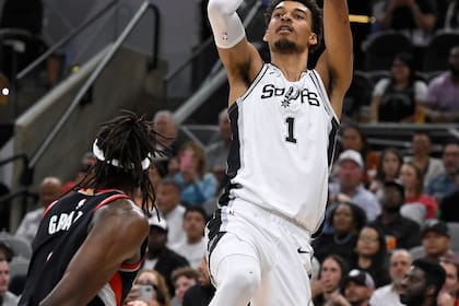 El francés Victor Wembanyama, de los Spurs de San Antonio, dispara frente a Jerami Grant, de los Trail Blazers de Portland, el jueves 7 de noviembre de 2024 (AP Foto/Darren Abate)
