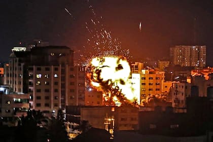 El fuego sale de un edificio golpeado por un ataque aéreo israelí en la Franja de Gaza, el 13 de mayo, en medio de la escalada de violencia israelí-palestina