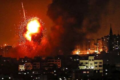El fuego sale de un edificio golpeado por un ataque aéreo israelí en la Franja de Gaza, en medio de la escalada de violencia israelí-palestina